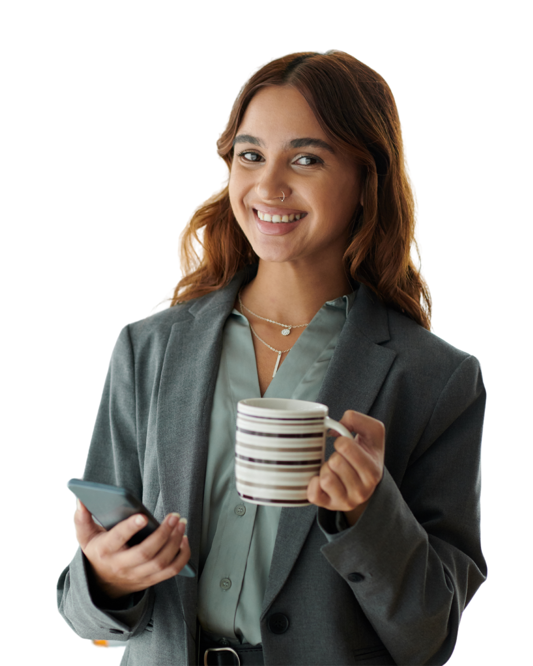 Meisje met bruine krullen, heeft een lach en een neuspiercing. Ze heeft een grijze blazer aan met een groene blouse eronder. Ze heeft een mok ik haar hand en in haar andere hand een telefoon.